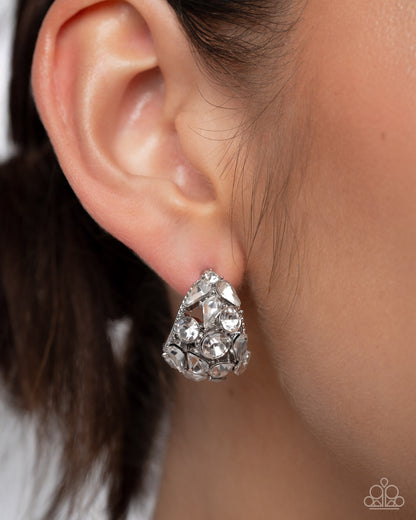 Close-up of a person wearing a silver teardrop earring.