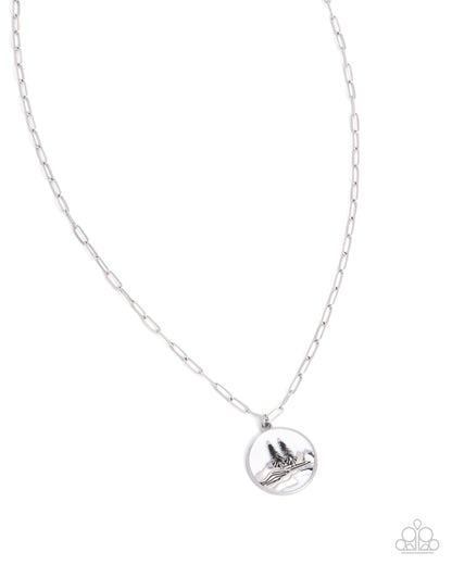 Silver necklace with a round pendant on a white background