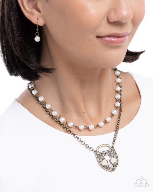 Pearl necklace with a lock charm worn by a model on a white background