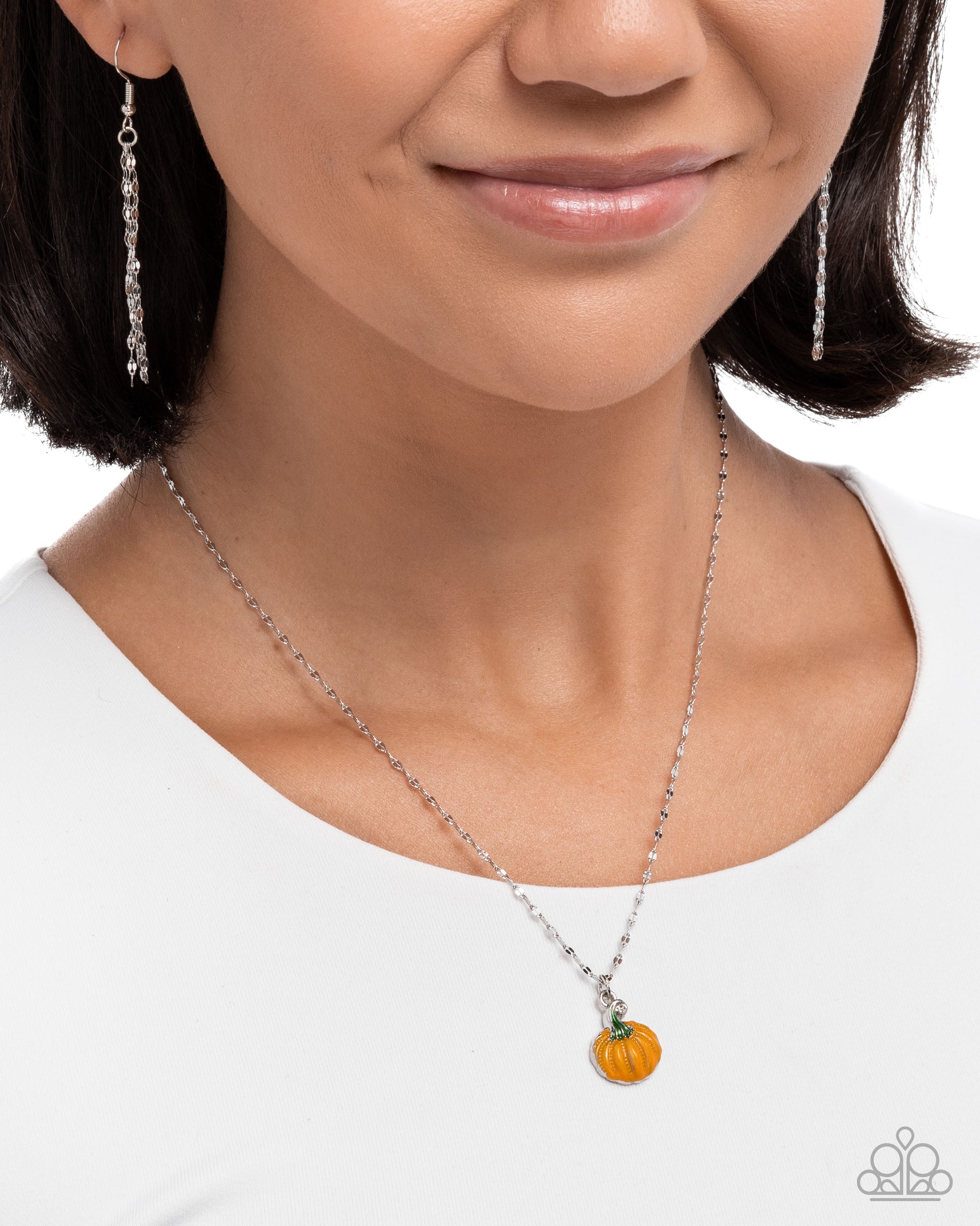 Necklace with a pumpkin charm worn by a model on a white background