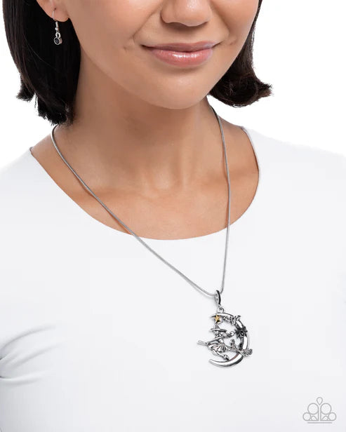 Woman wearing a silver necklace with a detailed pendant on a white background