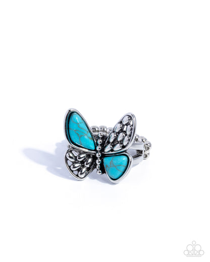 Butterfly-shaped ring with turquoise wings and silver accents on a white background