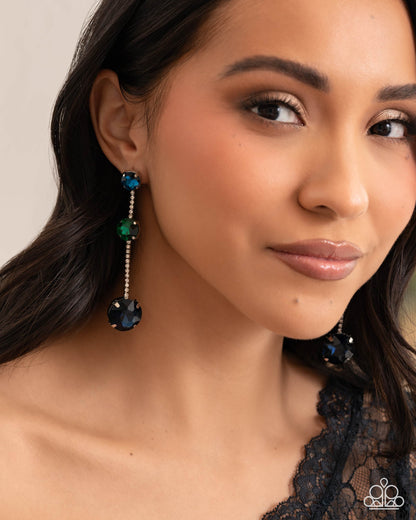 Close-up of a woman wearing blue earrings with a neutral background