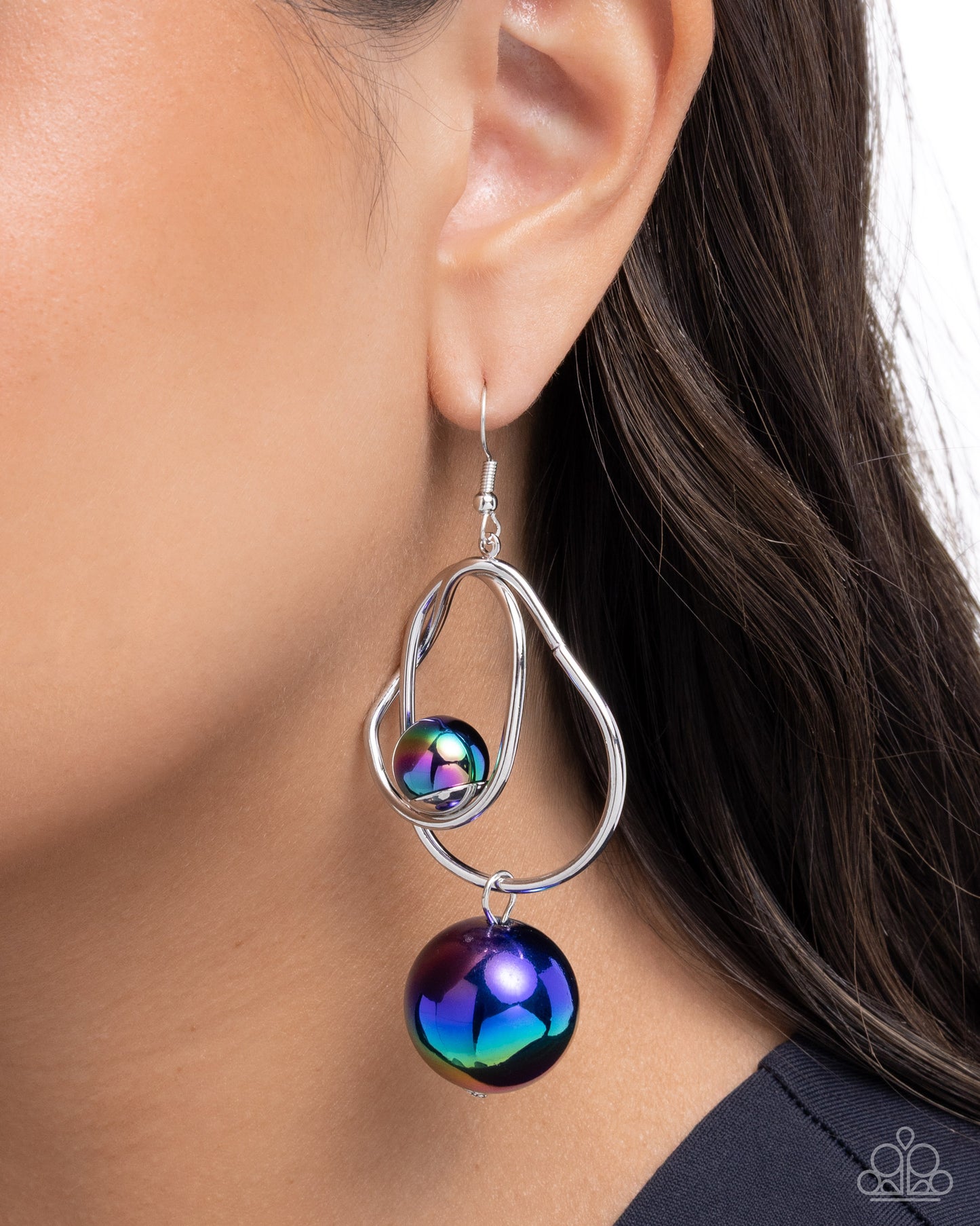Silver earring with a colorful bead worn by a person