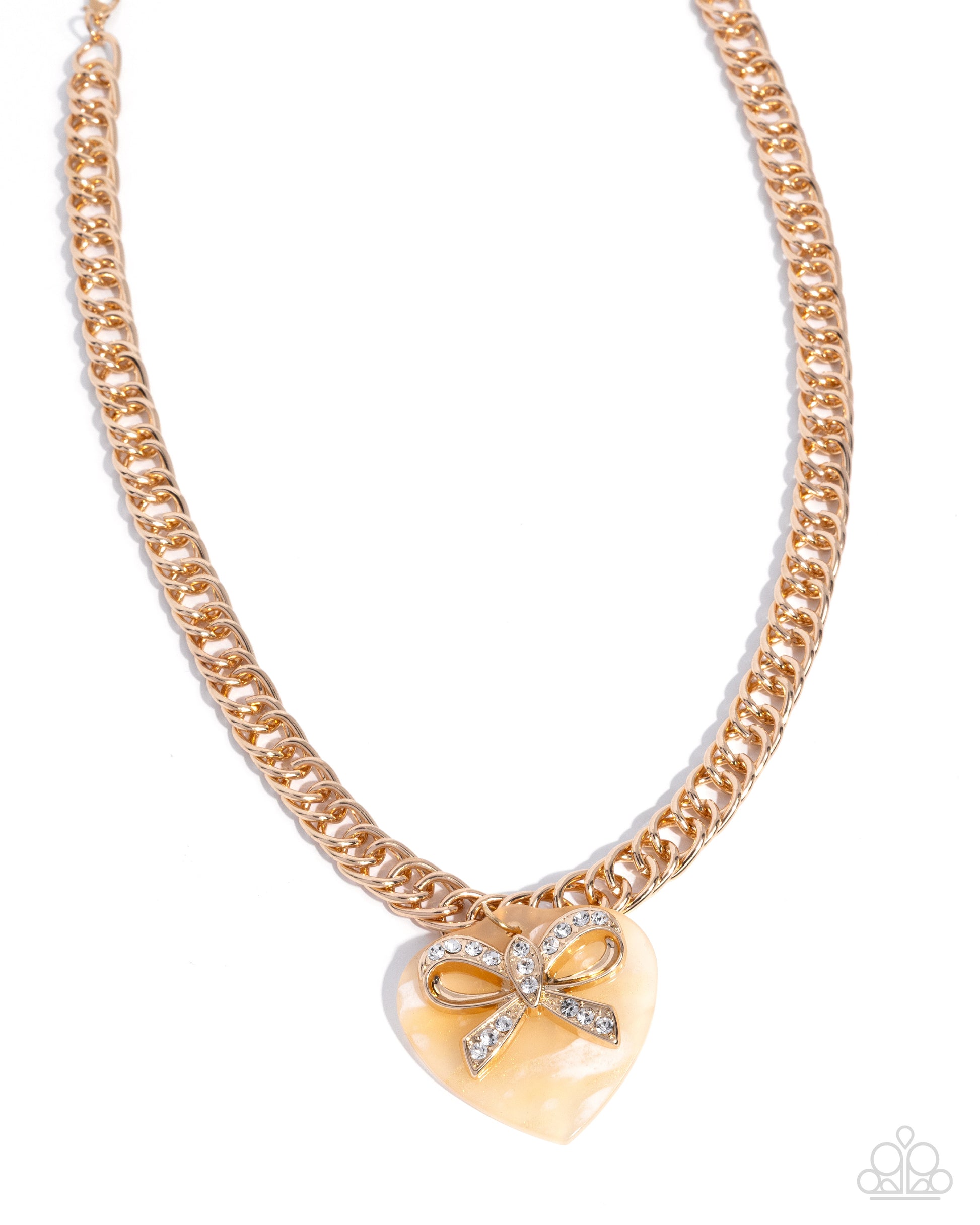 Gold chain necklace with a heart-shaped pendant featuring a bow design on a white background