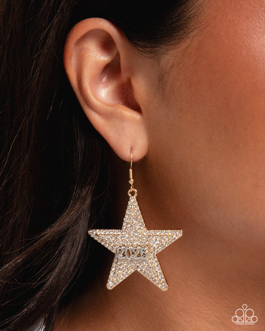 Star-shaped earring with '2023' on an ear against a brown background