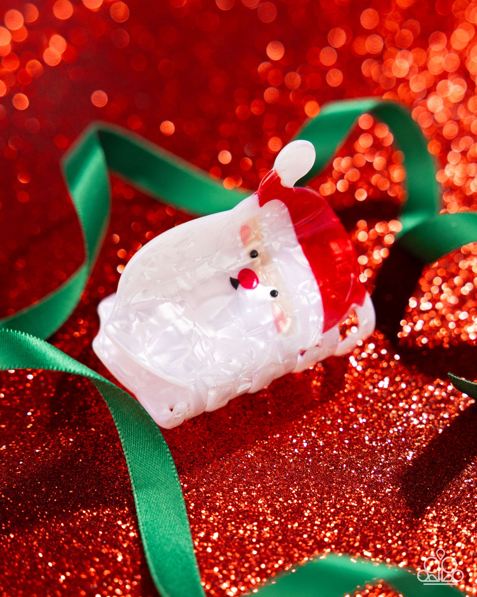 Decorative item resembling a snowman with a Santa hat on a red glittery background
