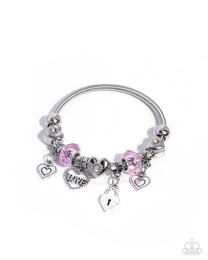 Silver bracelet with pink charms on a white background