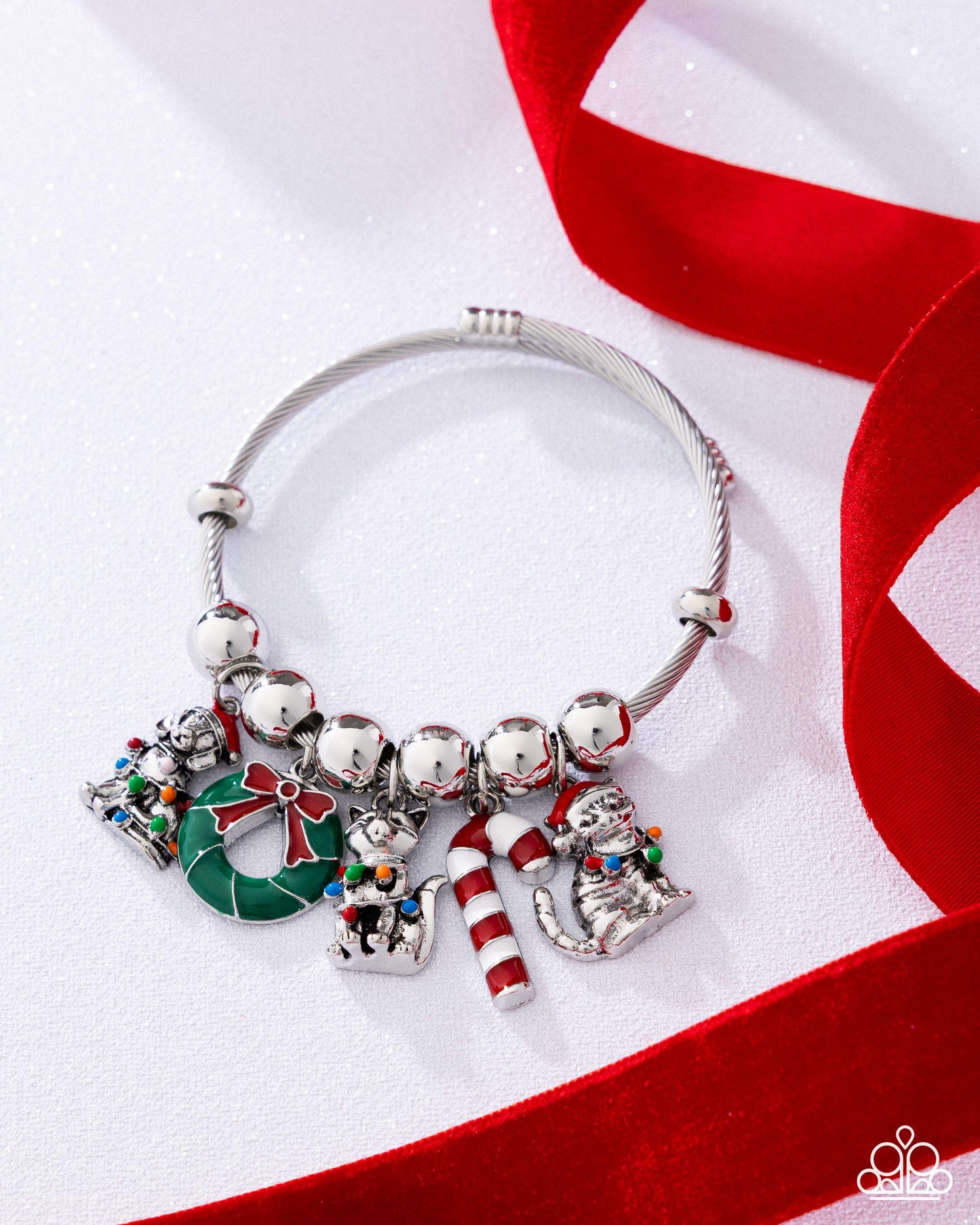 Silver bracelet with Christmas-themed charms on a red and white background