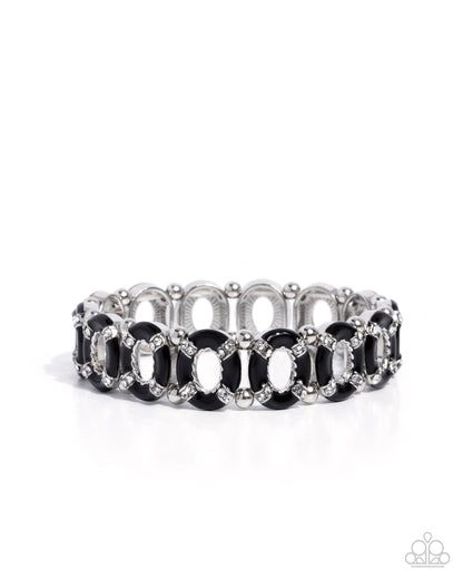 Silver bracelet with black and clear stones on a white background