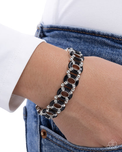 Bracelet on a wrist with a white shirt and blue jeans