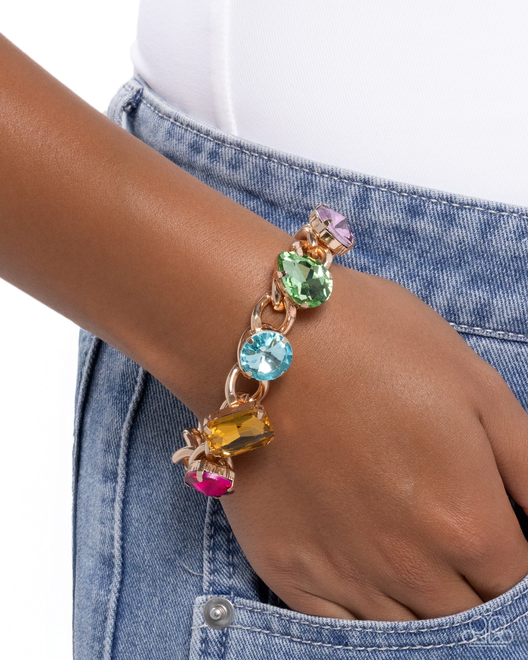 Multicolored gemstone bracelet on a wrist with a denim background