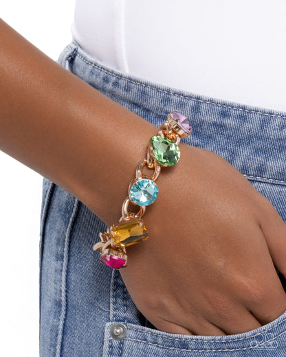 Multicolored gemstone bracelet on a wrist with a denim background