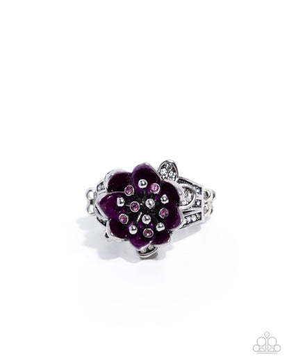 A silver-tone ring designed as a lotus flower, featuring deep purple enamel petals and small pink rhinestones in the center, set against a plain white background.