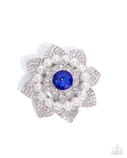 Floral brooch with pearls and a blue gemstone on a white background