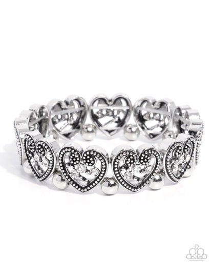 Silver bracelet with heart designs on a white background