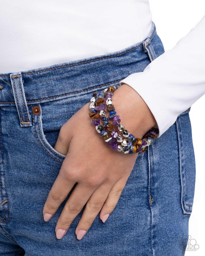 Person wearing colorful beaded bracelets on a white background
