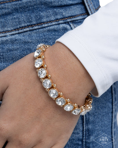 Bracelet with clear stones on a wrist against a denim background