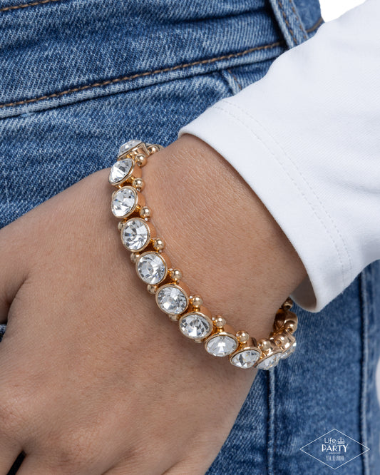 Bracelet with clear stones on a wrist against a denim background