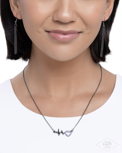 Close-up of a person wearing a necklace with heart-shaped pendant on a white background