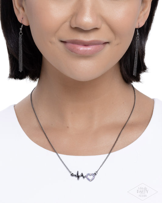 Close-up of a person wearing a necklace with heart-shaped pendant on a white background