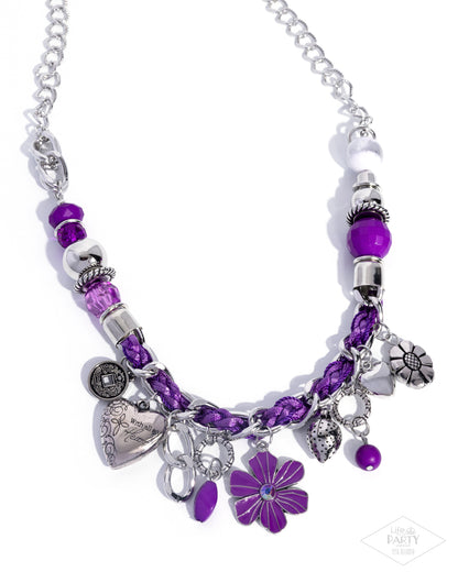 Necklace with purple beads and charms on a white background
