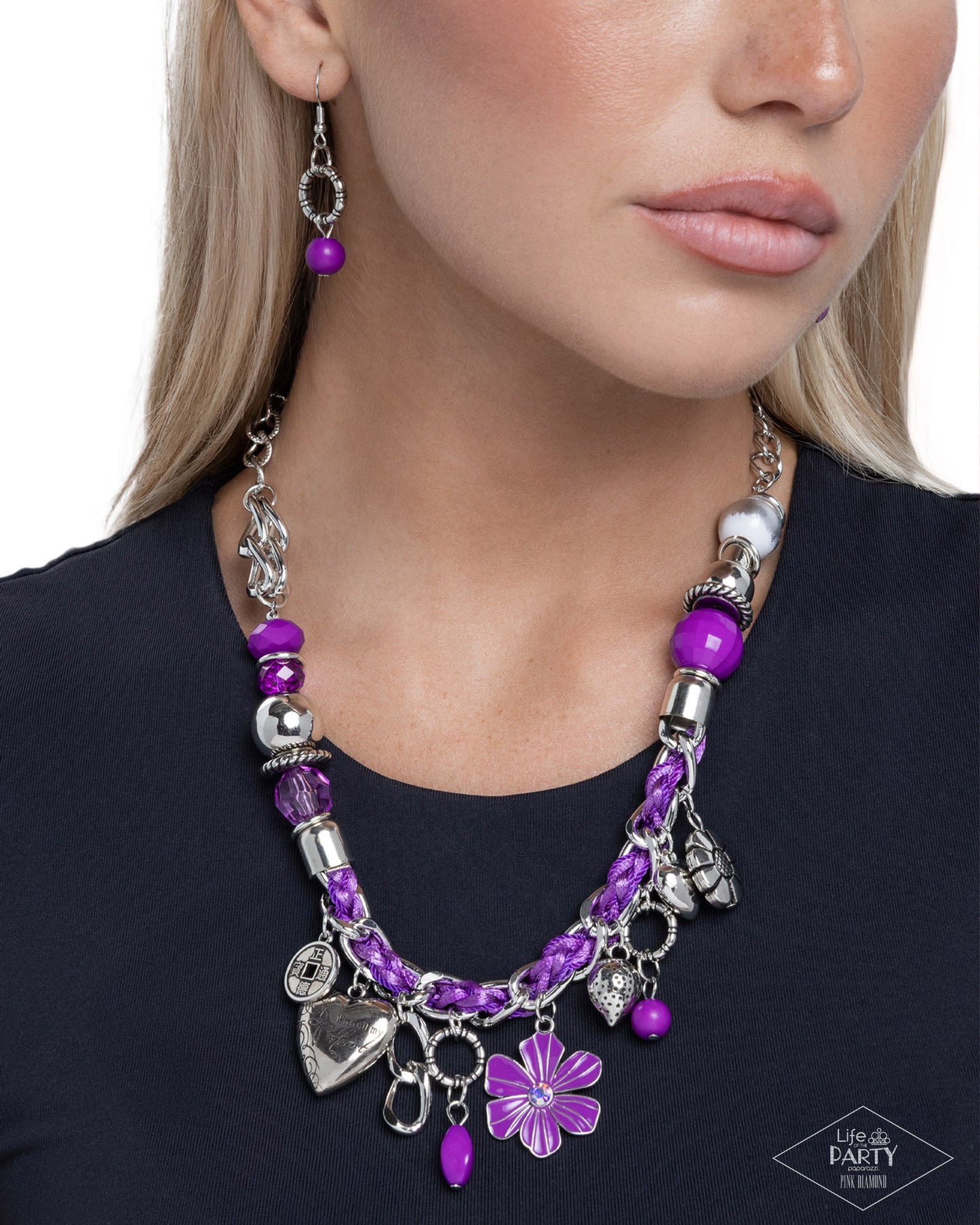 Purple beaded necklace with silver charms worn by a model on a white background
