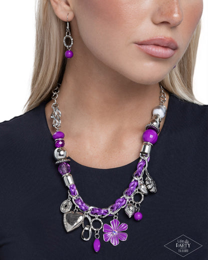 Purple beaded necklace with silver charms worn by a model on a white background