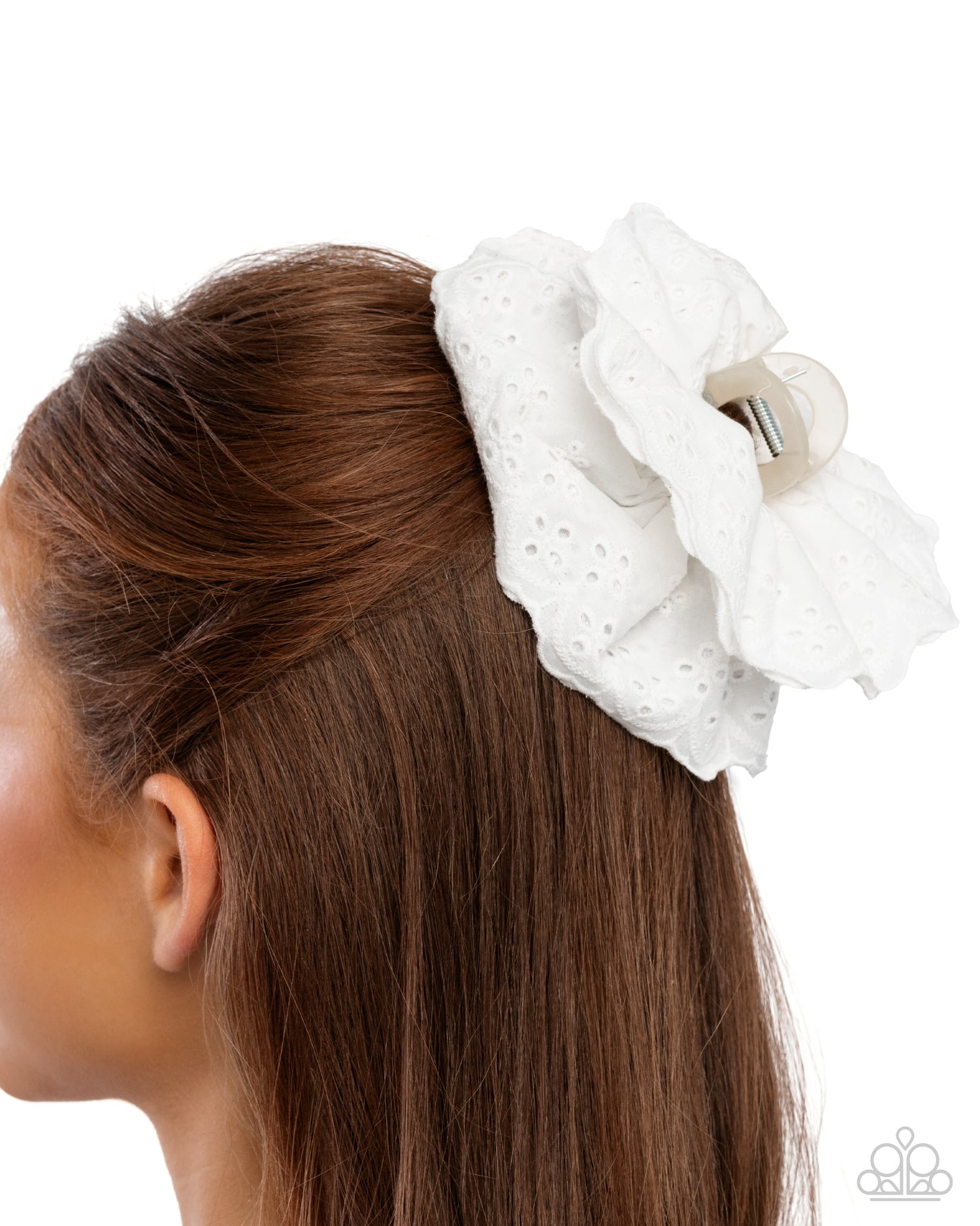 White polka dot scrunchie on a person's hair against a white background