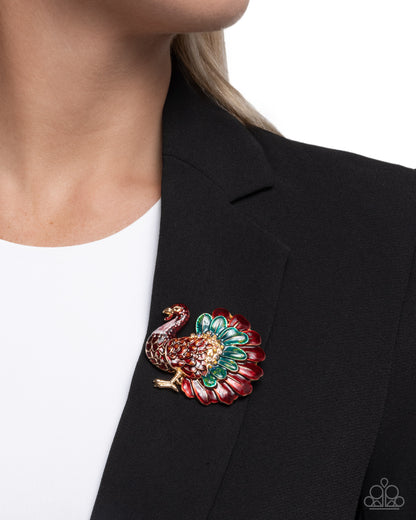 Colorful peacock brooch on a black blazer against a white background