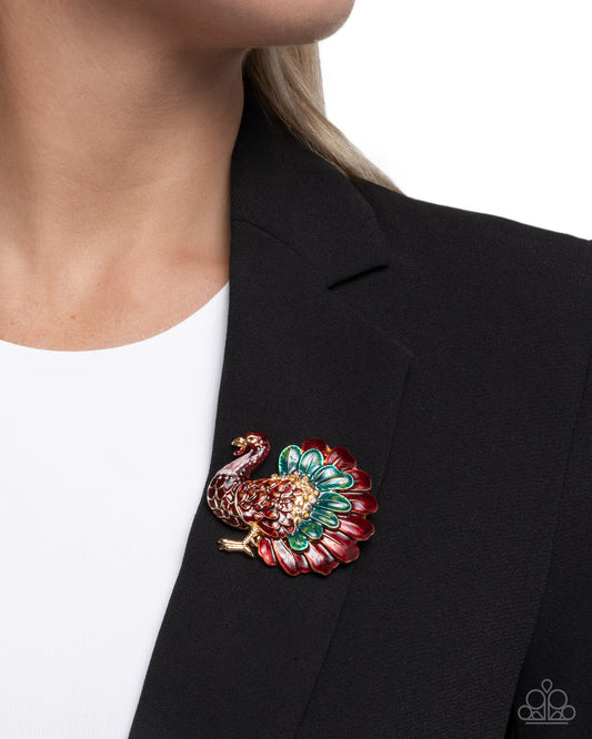 Colorful peacock brooch on a black blazer against a white background