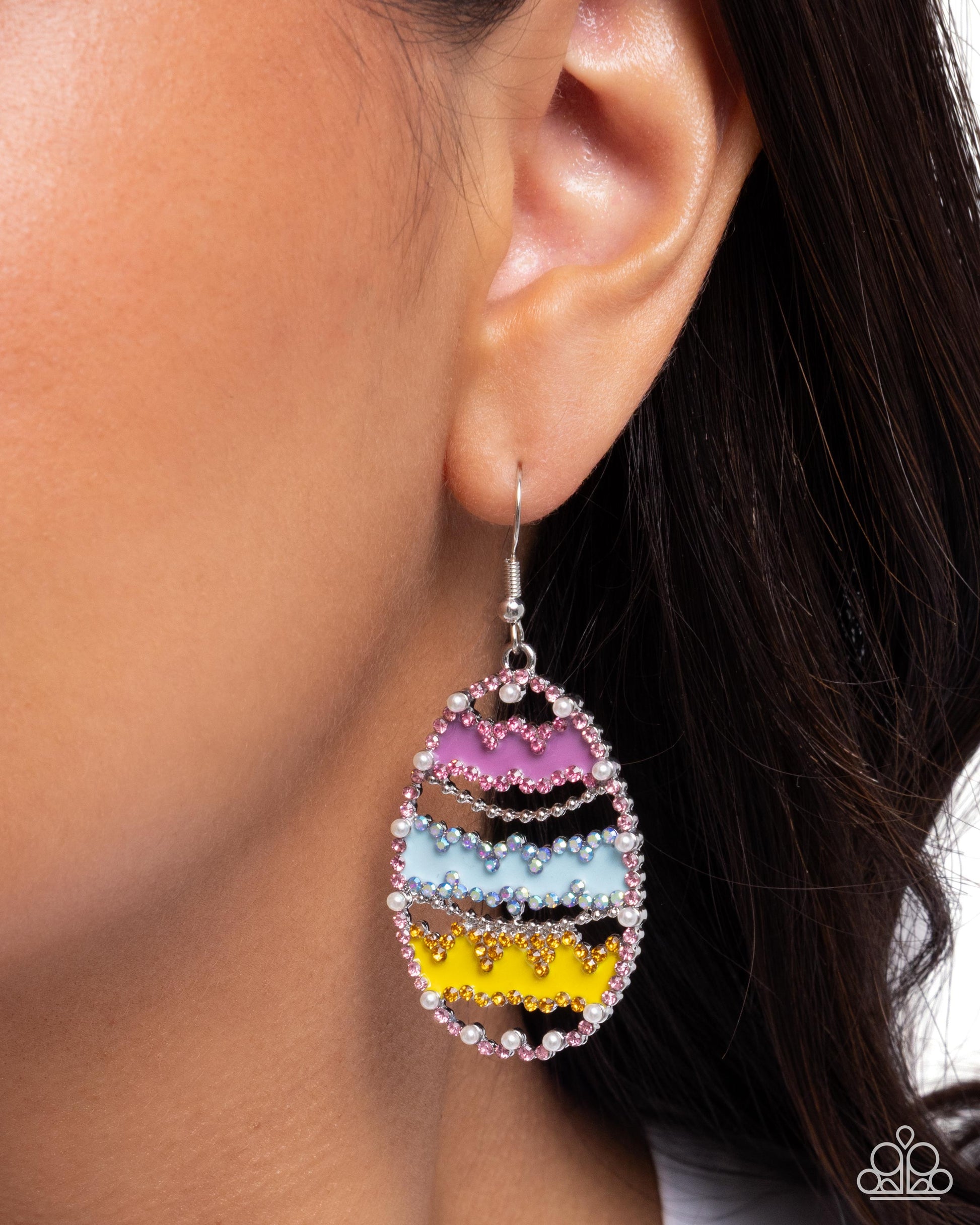 Colorful teardrop earring worn by a person with dark hair.
