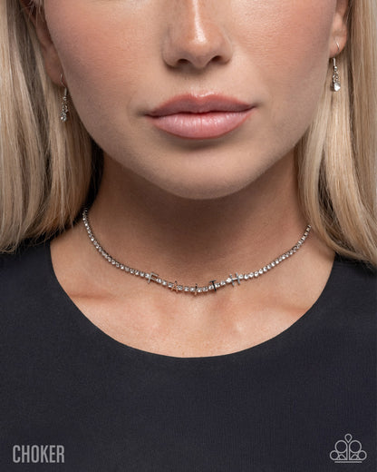 Close-up of a woman wearing a choker necklace with a plain background