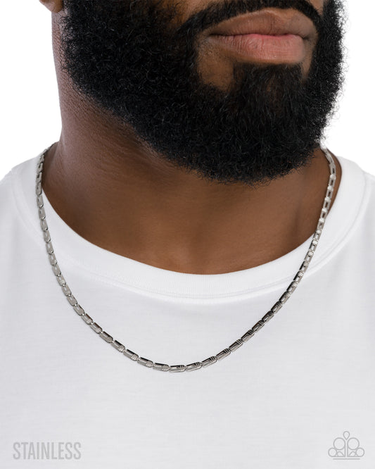 Man wearing a silver chain necklace on a white background