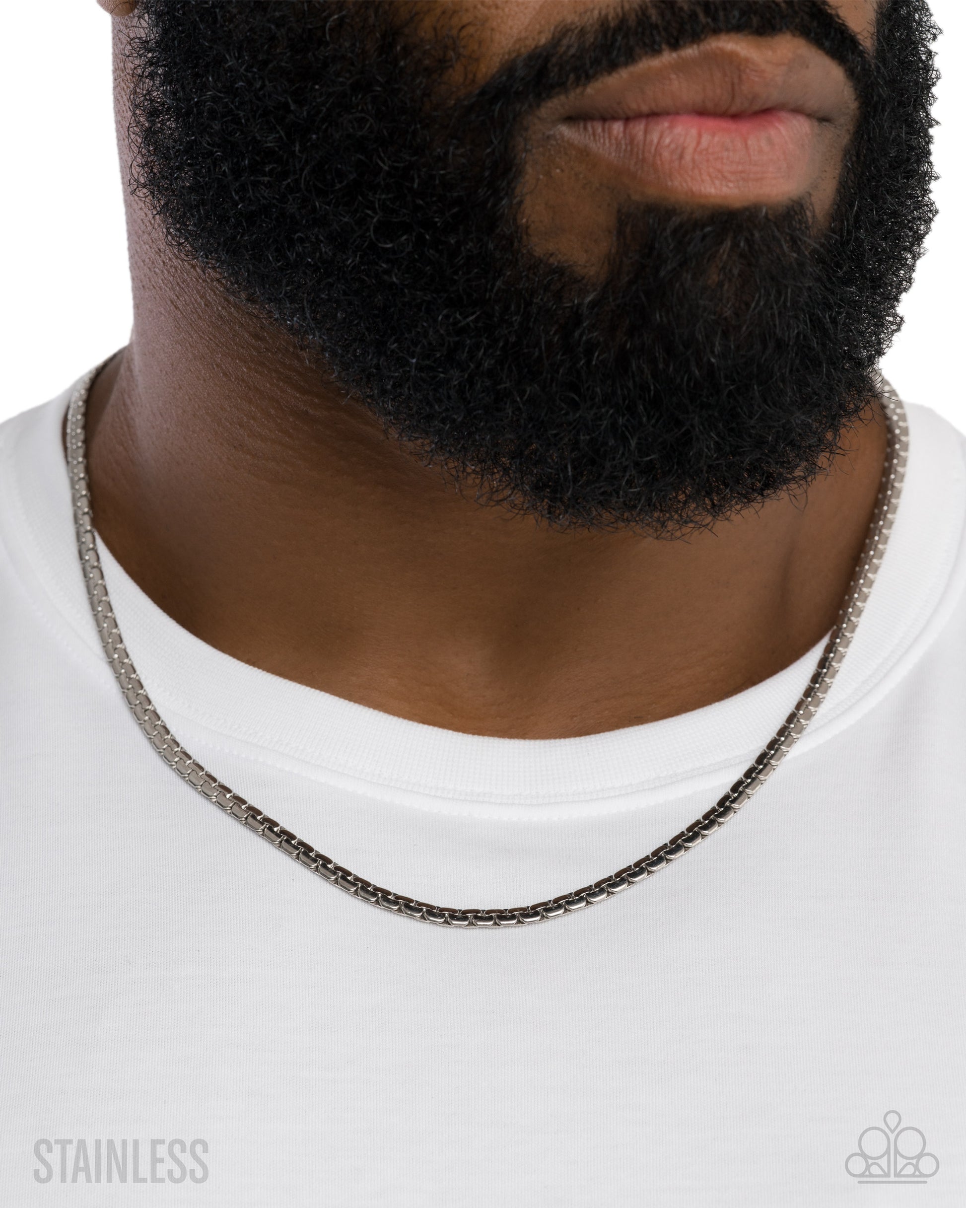Close-up of a person wearing a silver chain necklace on a white background