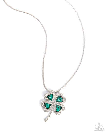 Four-leaf clover pendant necklace with green gemstones on a white background