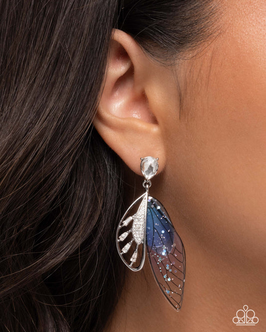 Earring worn by a person with dark hair, close-up of ear and earring.