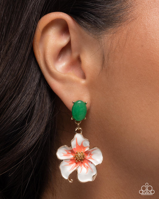 Close-up of an ear wearing a floral earring with a green gemstone.