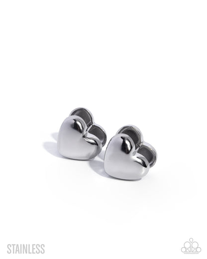 Pair of silver heart-shaped earrings on a white background