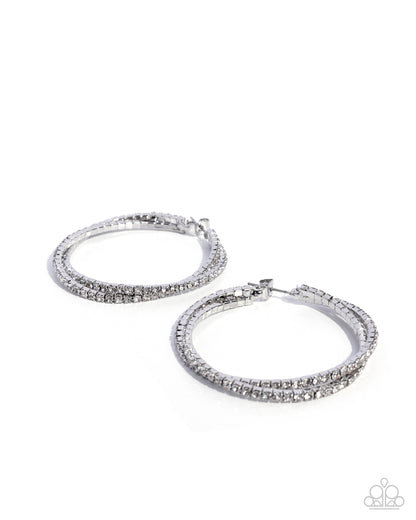 Pair of silver hoop earrings with clear gemstones on a white background
