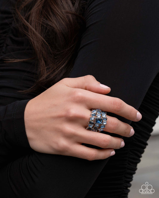 Close-up of a hand wearing a decorative ring with a black background