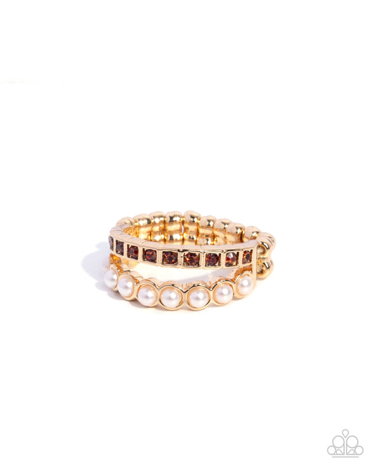 Set of gold and pearl bracelets on a white background