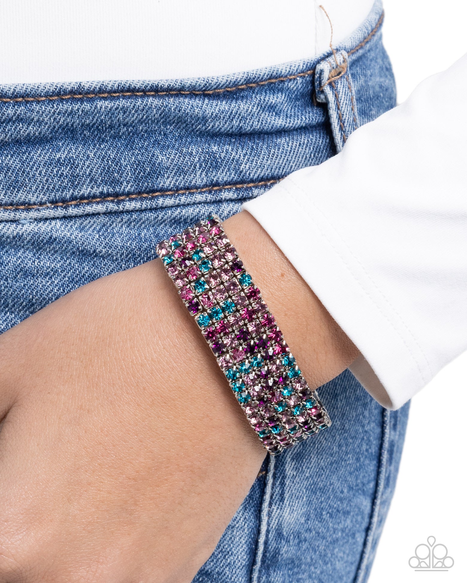 Multicolored beaded bracelet on a wrist with denim jeans and a white shirt.