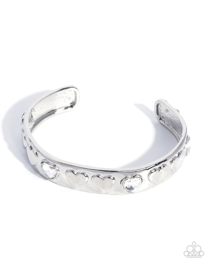 Silver bracelet with heart and circle designs on a white background