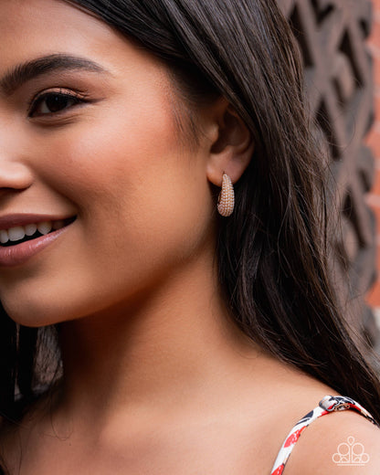 Close-up of a woman wearing a sparkling earring with a decorative background