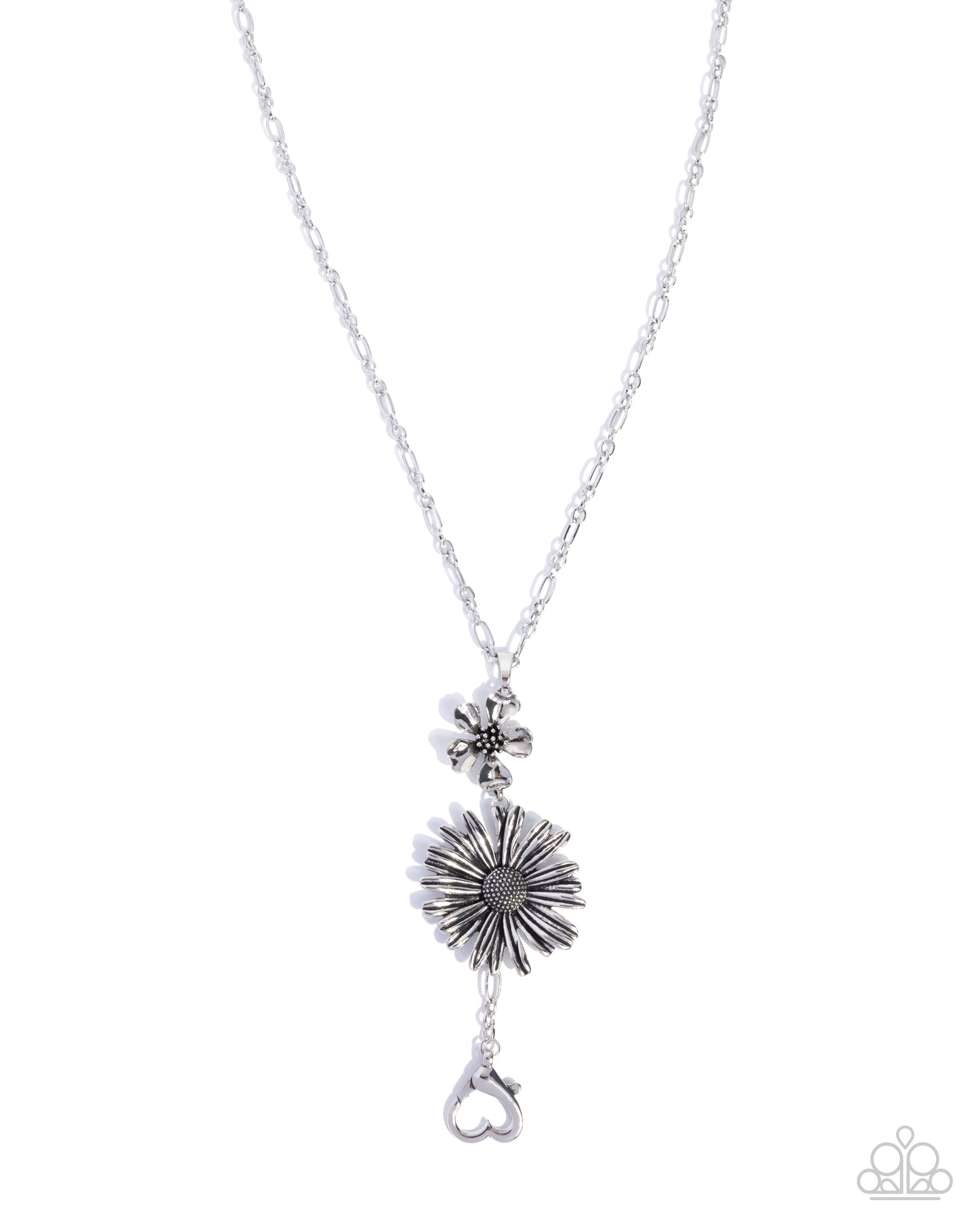Silver necklace with a starburst pendant and heart charm on a white background