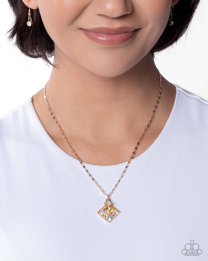 Person wearing a gold necklace with a square pendant on a white background