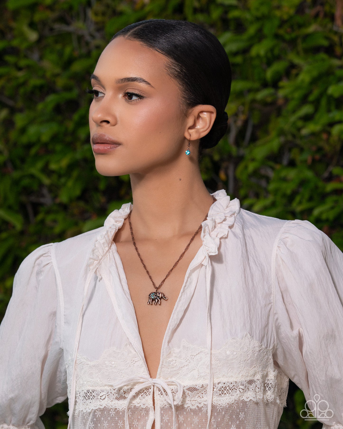 Woman wearing a white blouse with a green leafy background
