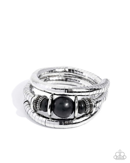 Stack of silver rings with black stones on a white background