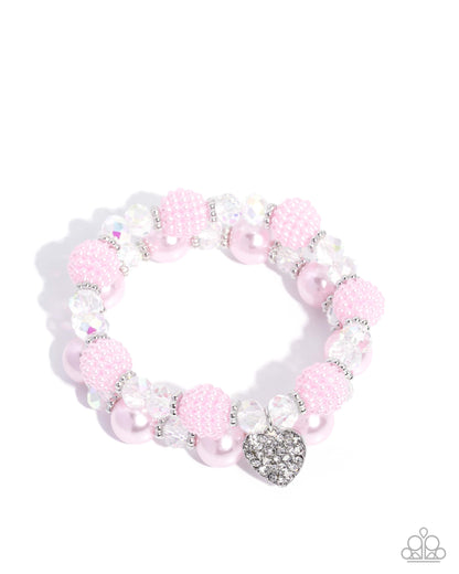 Pink beaded bracelet with a heart charm on a white background